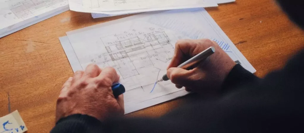 Property valuer analysing house blueprints at desk